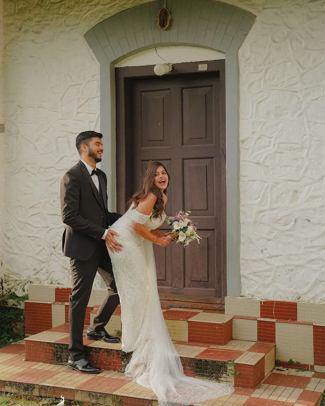 Bride and groom posing outside a heritage home