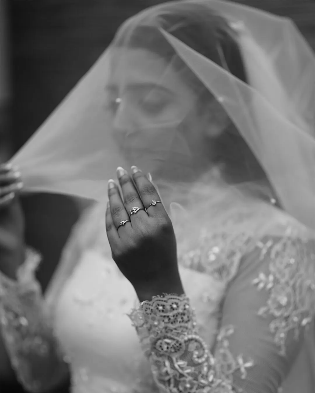 Black-and-white bridal portrait beneath a veil