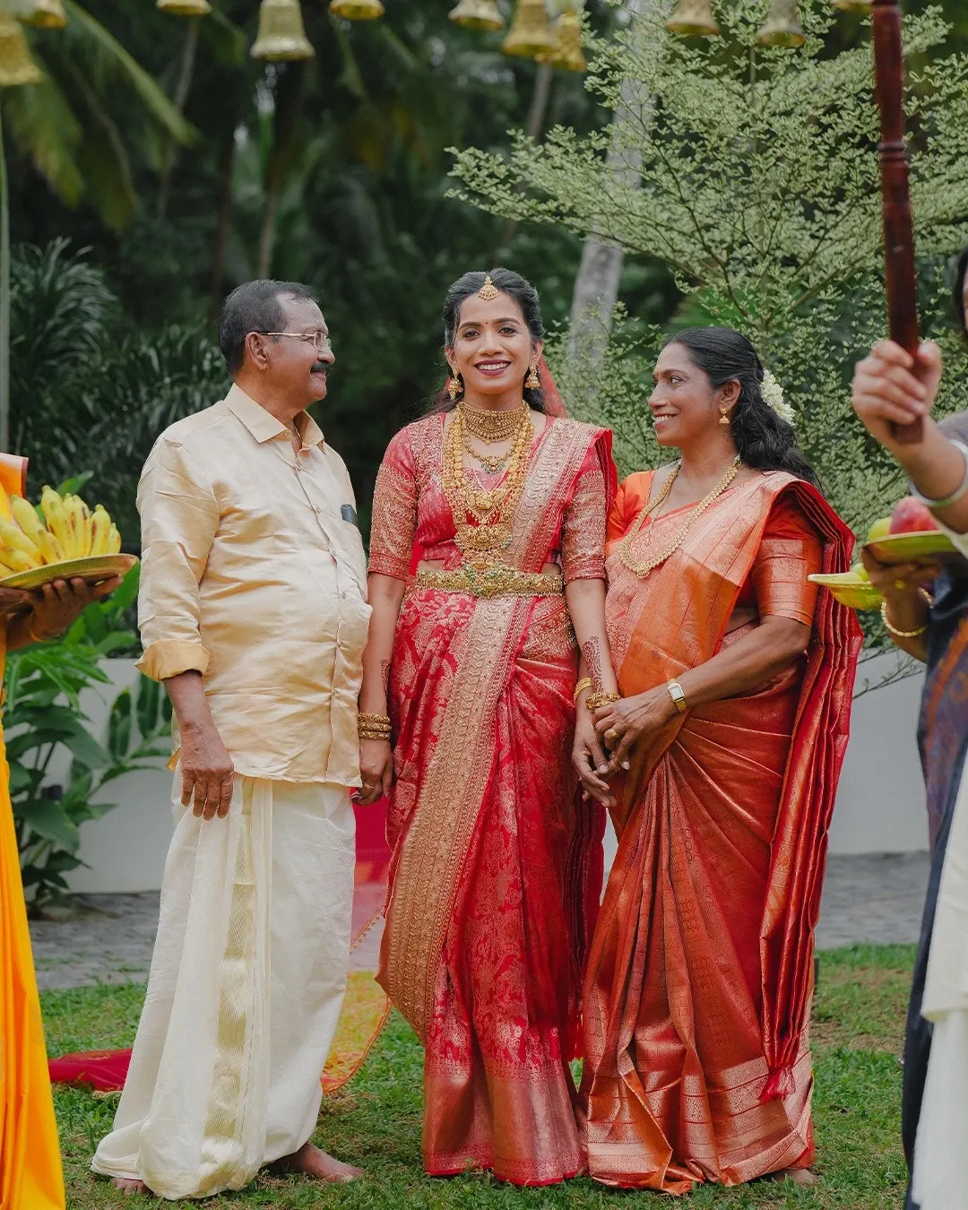 Bride smiling with her family during a Kerala wedding