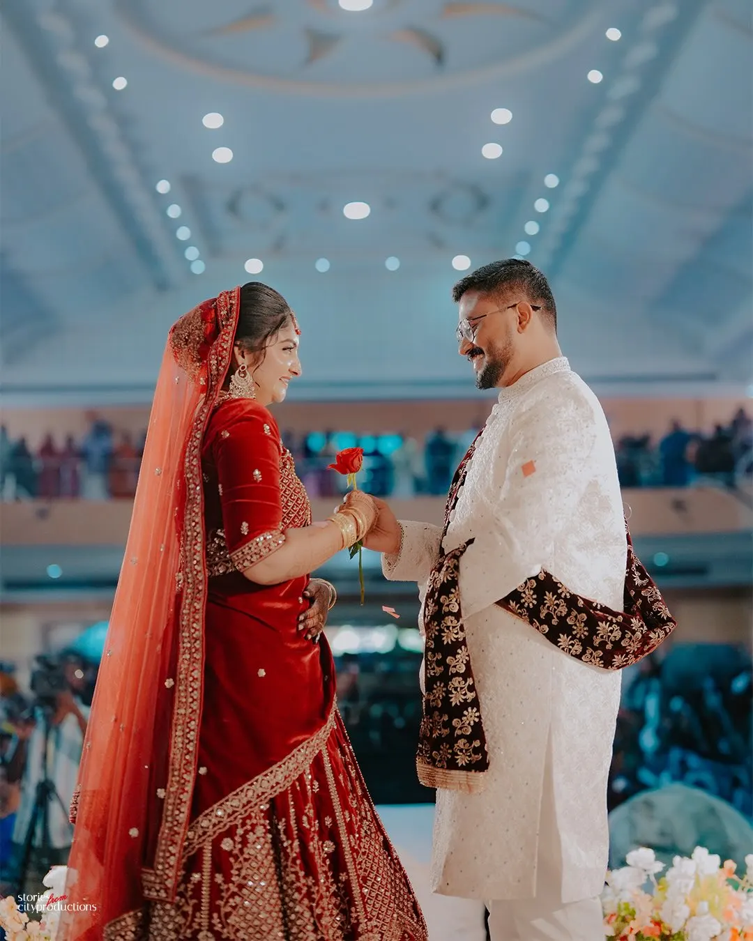 Bride and groom smiling beneath reception lights